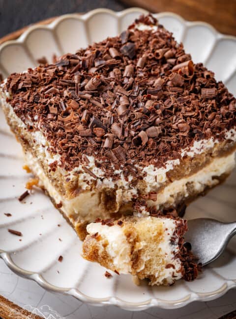 A plated slice of classic tiramisu topped with bittersweet chocolate shavings.