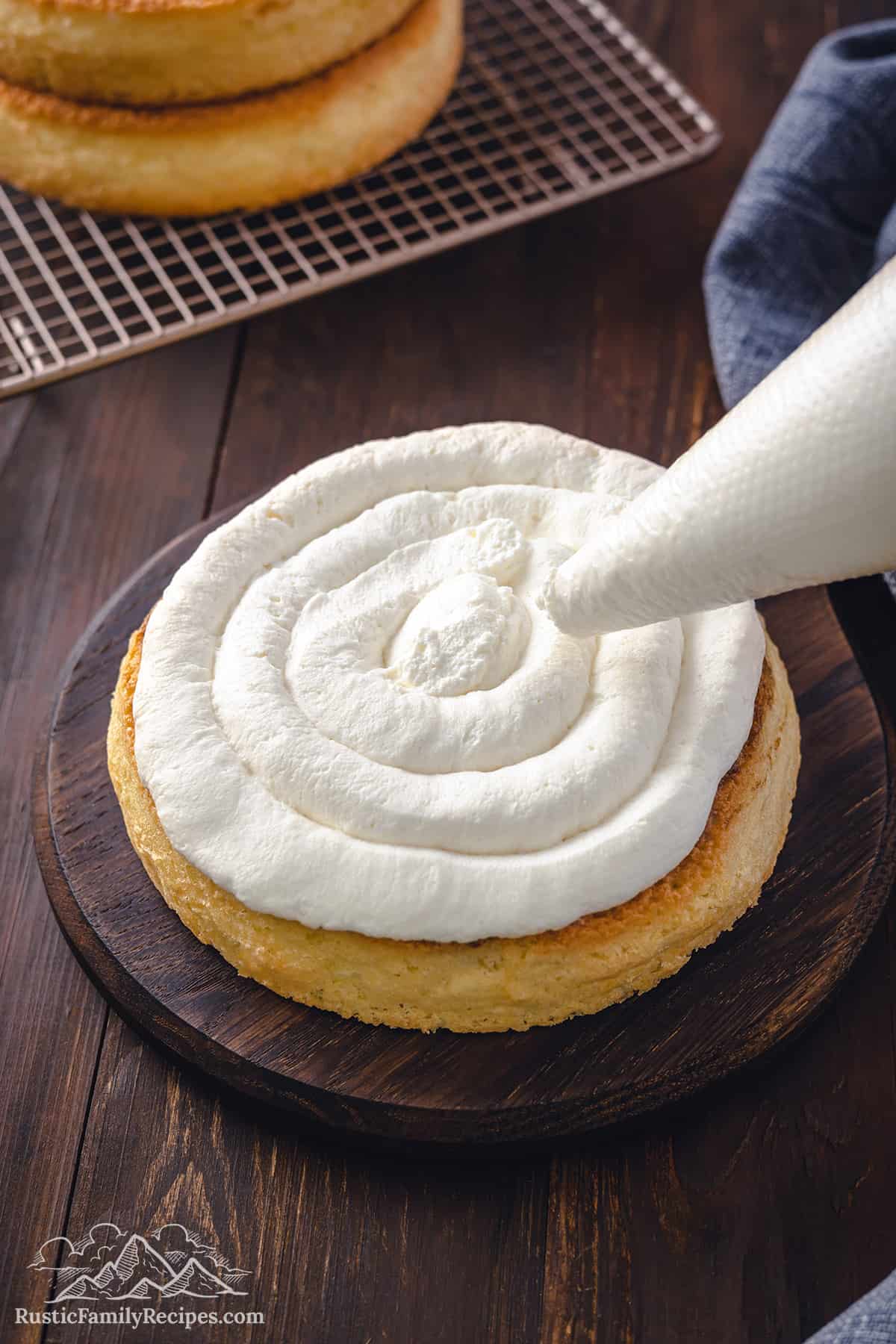 Piping mascarpone cream on a coffee-soaked genoise sponge cake. 
