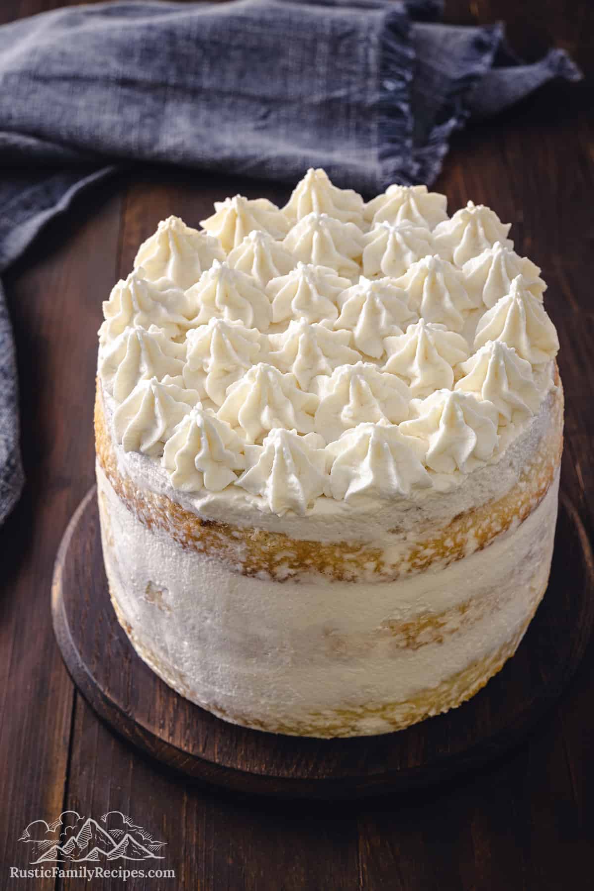 Top of a layered tiramisu cake decorated with mascarpone cream.