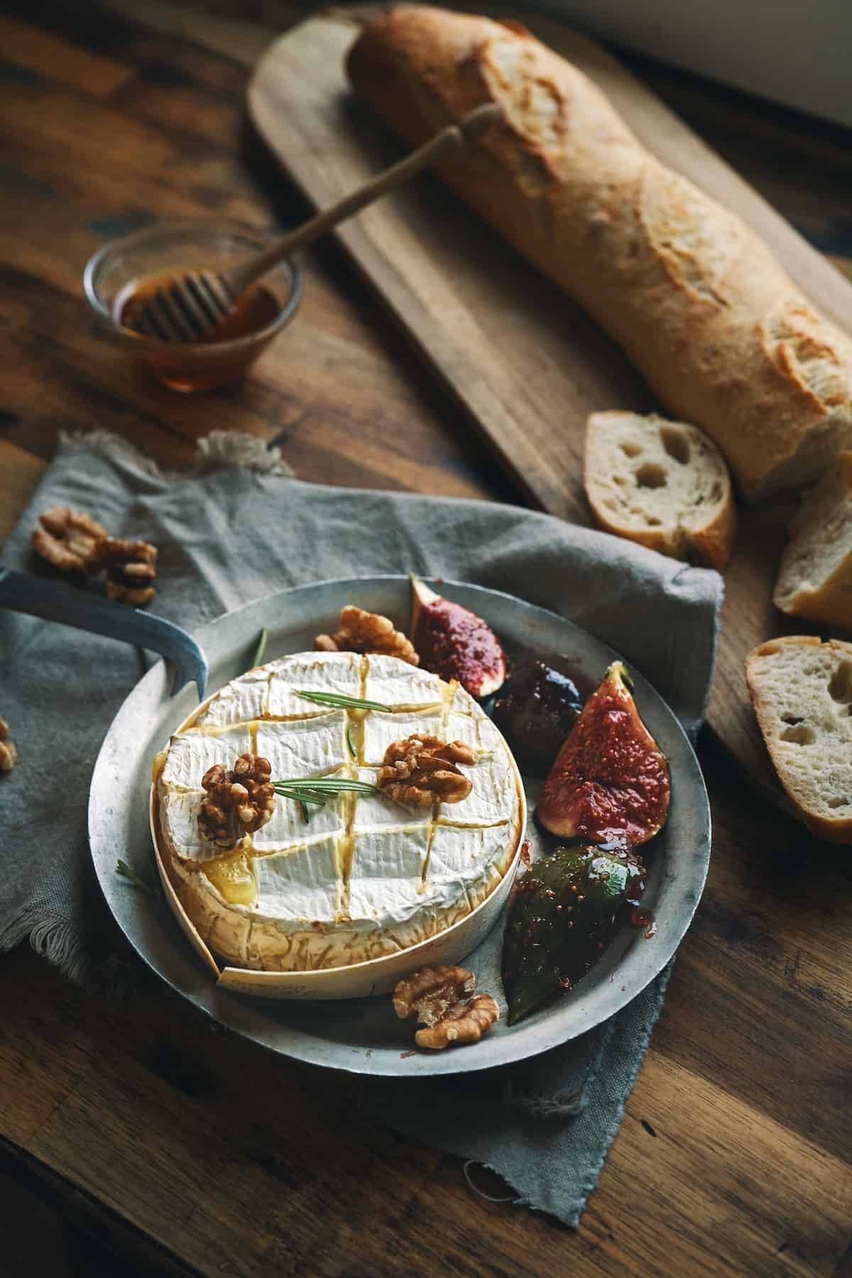 Baked camembert cheese with bread, walnuts and figs