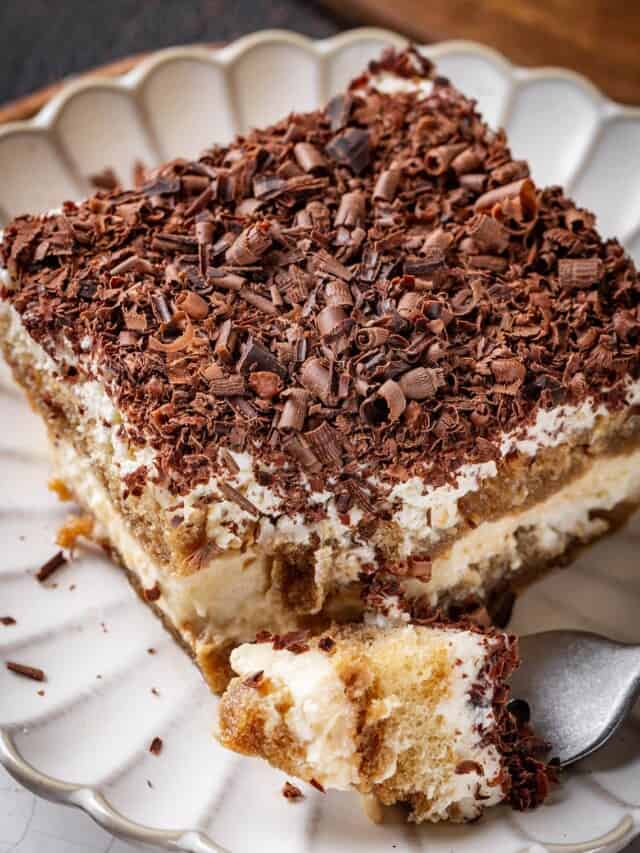 A plated slice of classic tiramisu topped with bittersweet chocolate shavings.