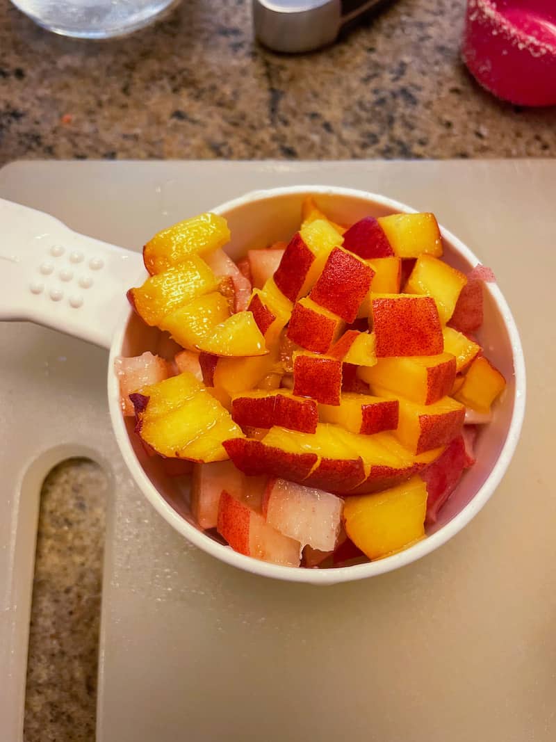 Diced peaches in a measuring cup