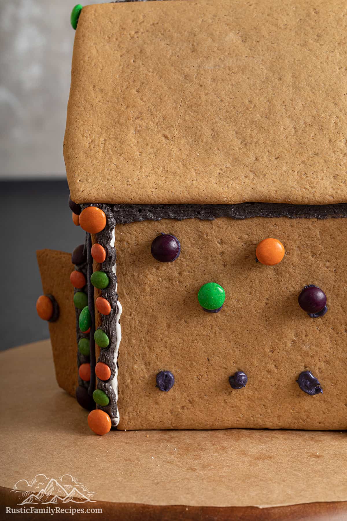 Gluing mini M&M's to the gingerbread house.