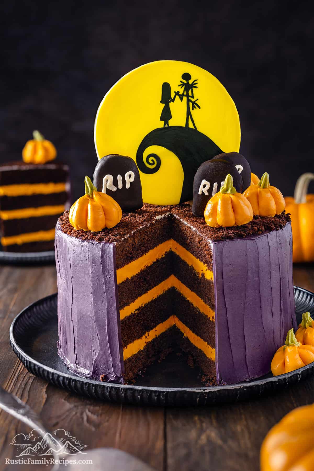 Jack Skellington cake with a slice taken out so you can see the layers of chocolate cake and orange buttercream