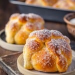 Pan de muerto on a plate with the recipe name on top.