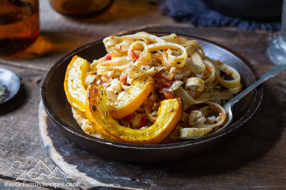 A plate with goat cheese pasta and roasted delicata squash