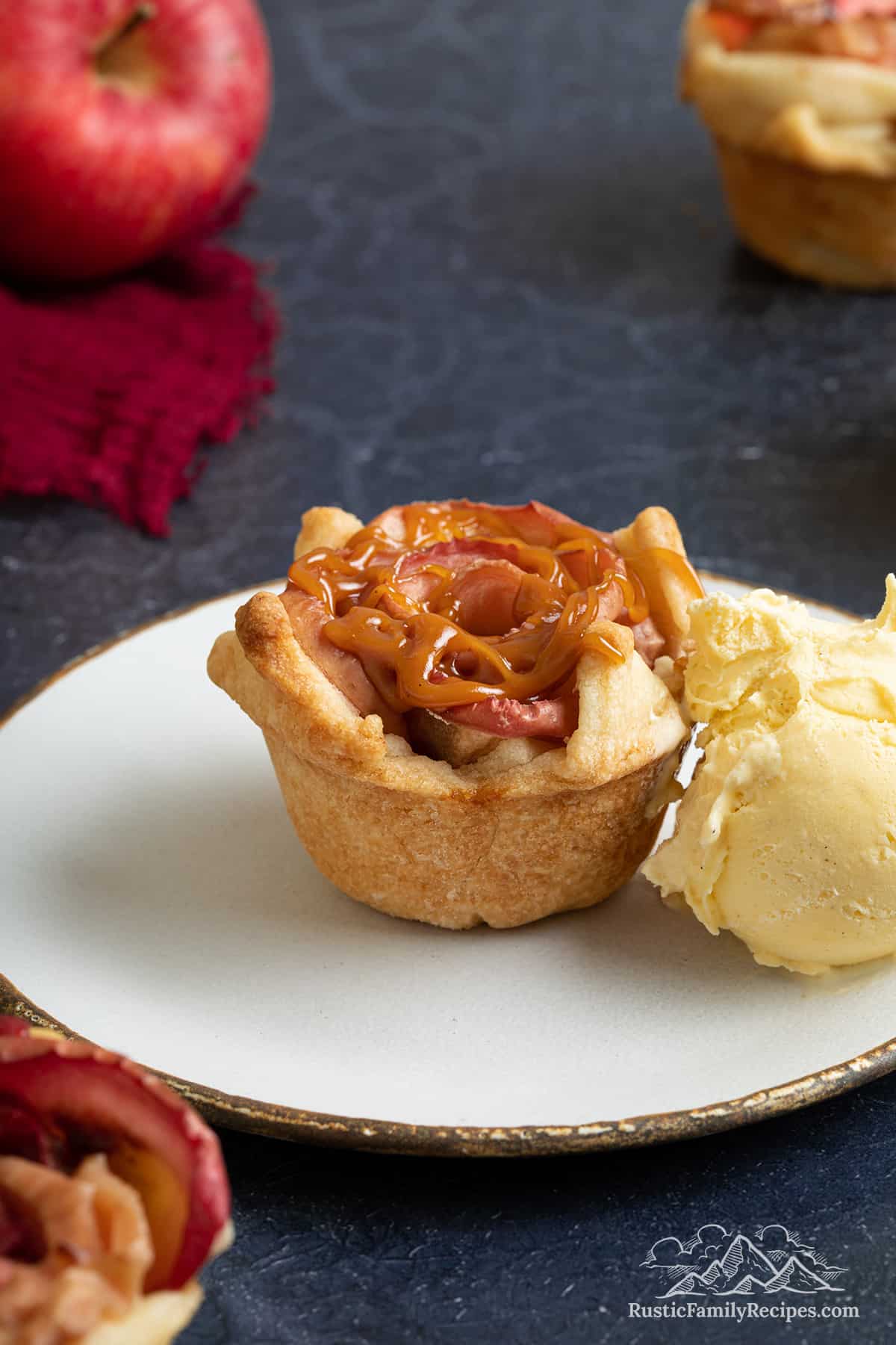 An apple tartlet on a plate with ice cream