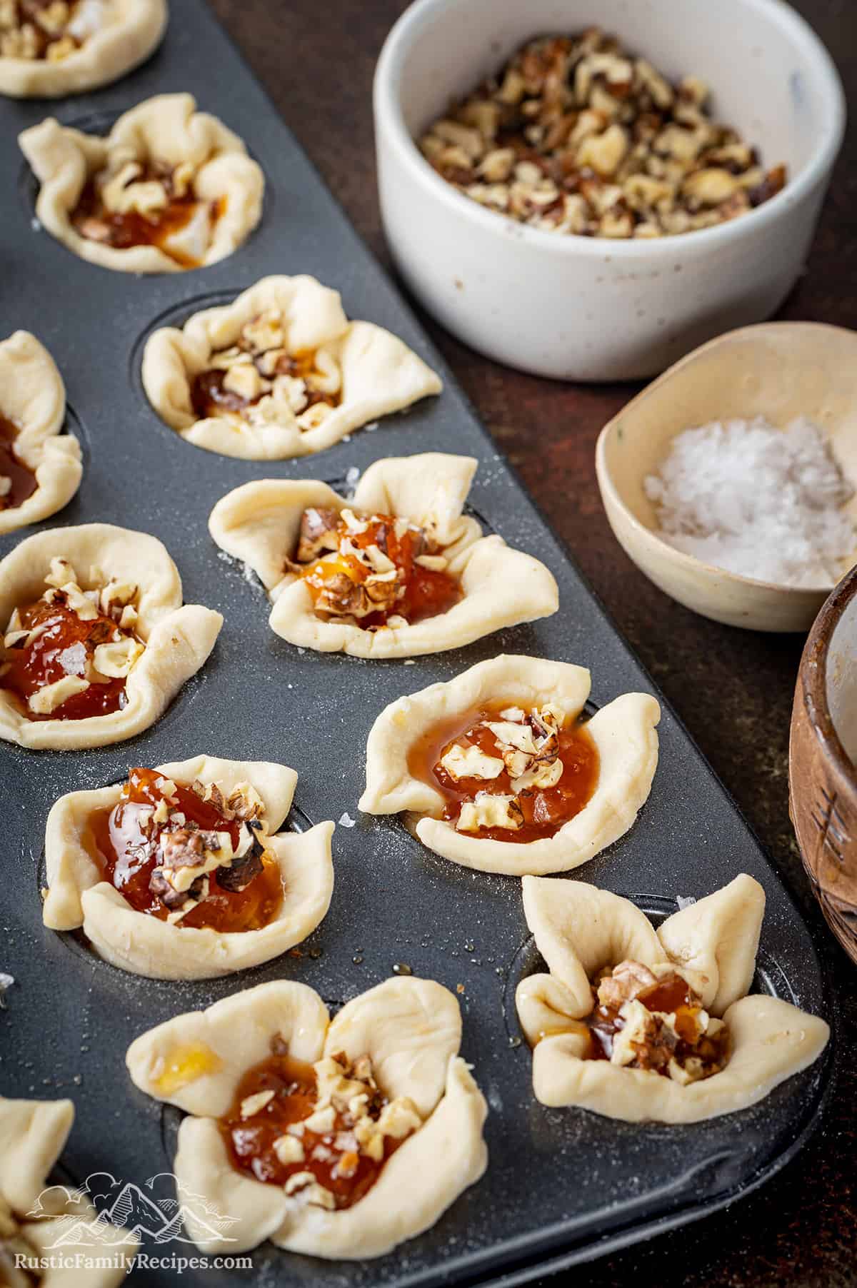 Apricot brie bites before baking next to salt and walnuts