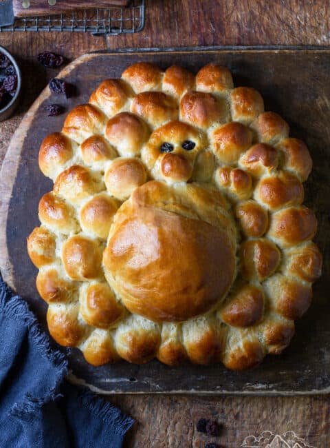 A loaf of turkey challah bread on a wood board