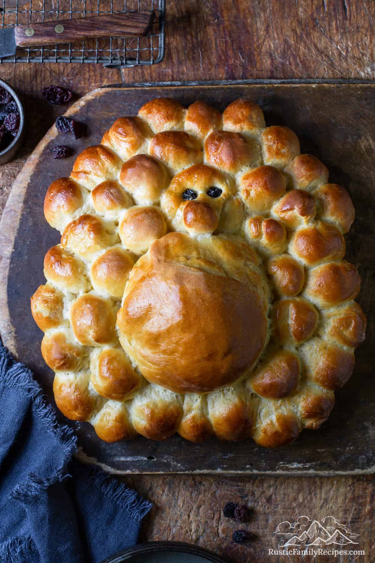 A loaf of turkey challah bread on a wood board