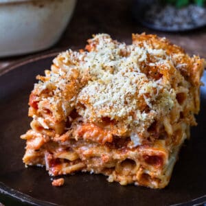 A slice of baked ziti al forno on a rustic plate