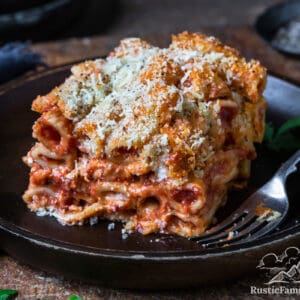 A slice of baked ziti al forno on a rustic plate