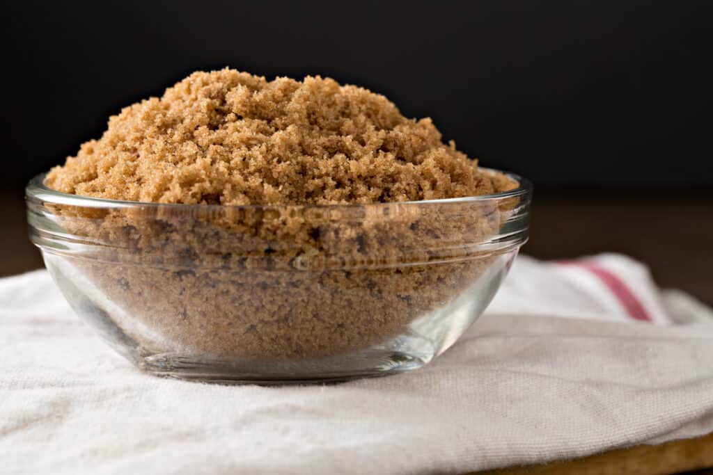 A bowl of brown sugar on a kitchen towel
