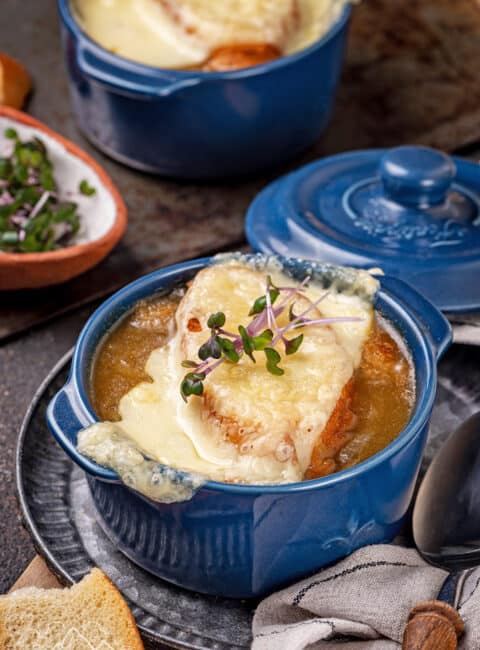 A blue ramekin with french onion soup