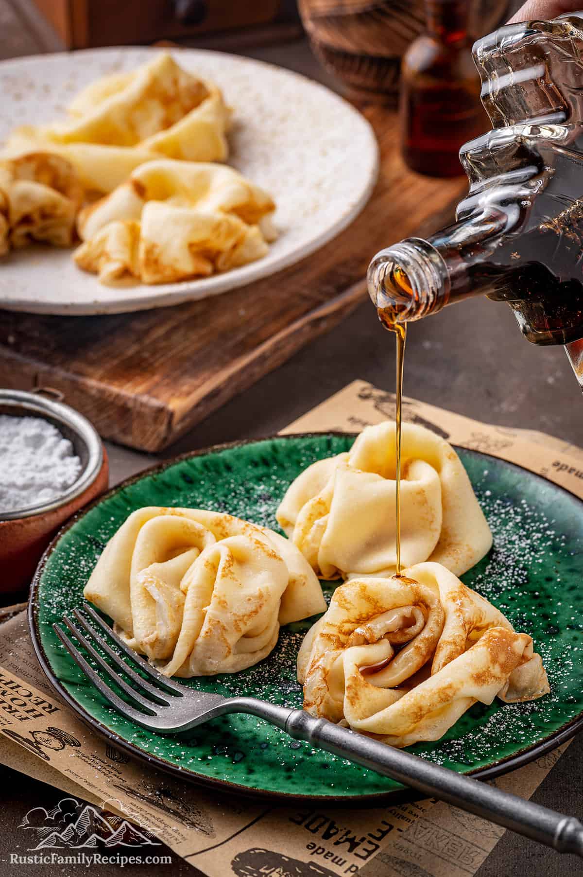 Pouring maple syrup onto 3 Frumple Cakes