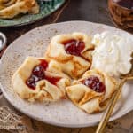 Frumple Cakes on a white plate with strawberry jam and whipped cream