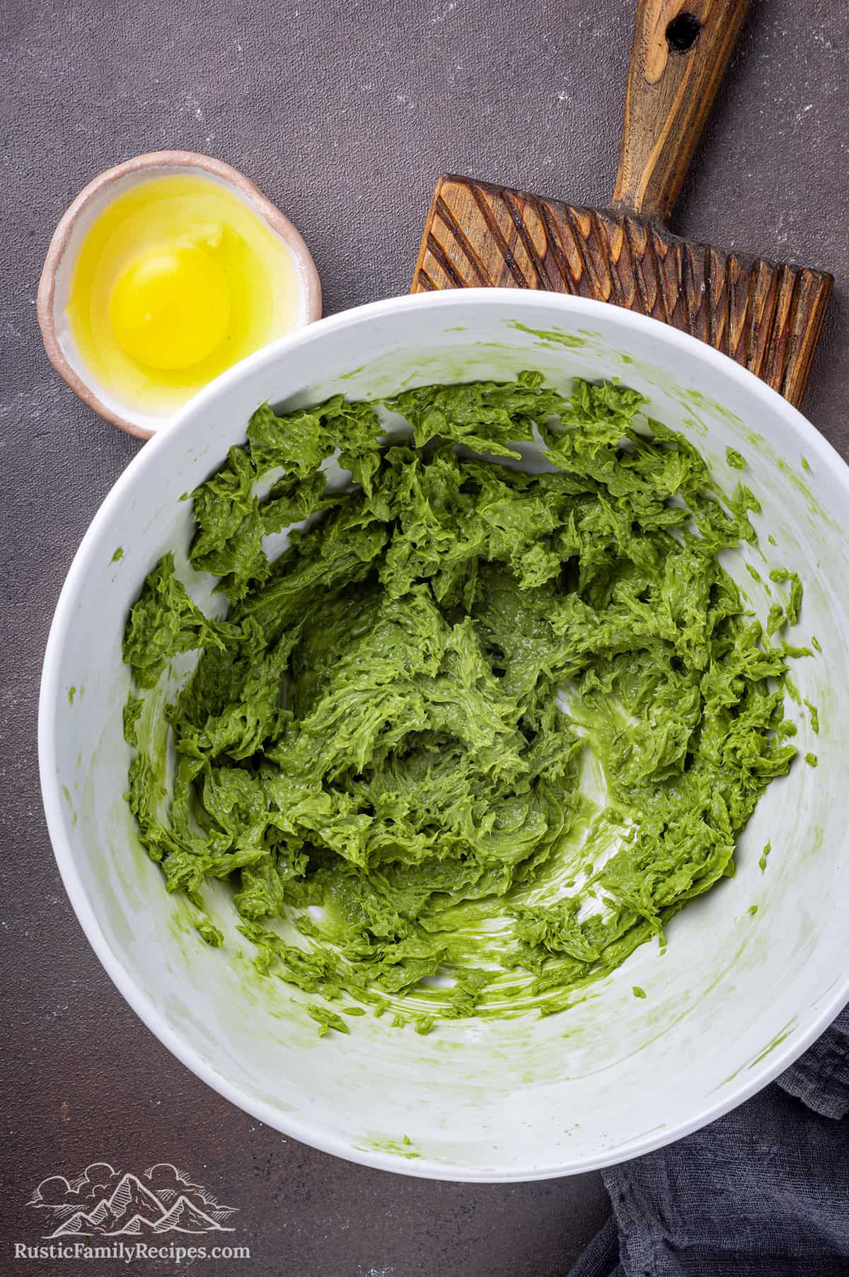 Green matcha creamed with butter and sugar in a bowl
