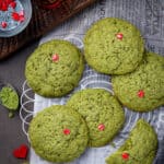 Green Grinch Cookies on parchment with festive decorations