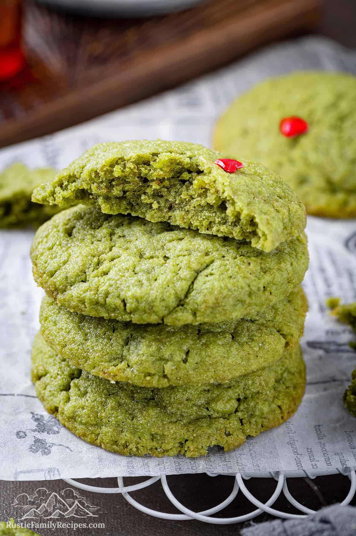 Stack of 4 green grinch cookies one with a bite taken out on top