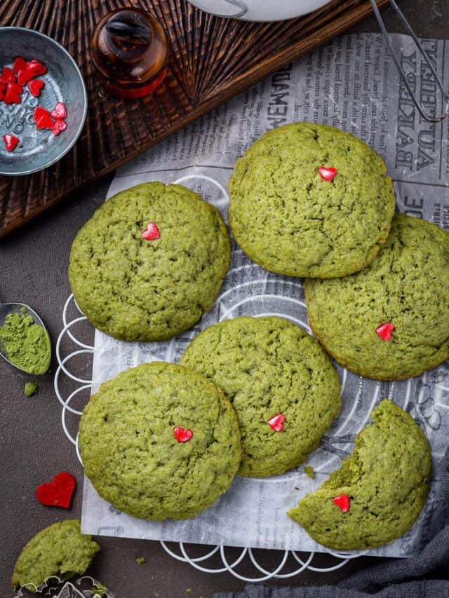 Green Grinch Cookies on parchment with festive decorations