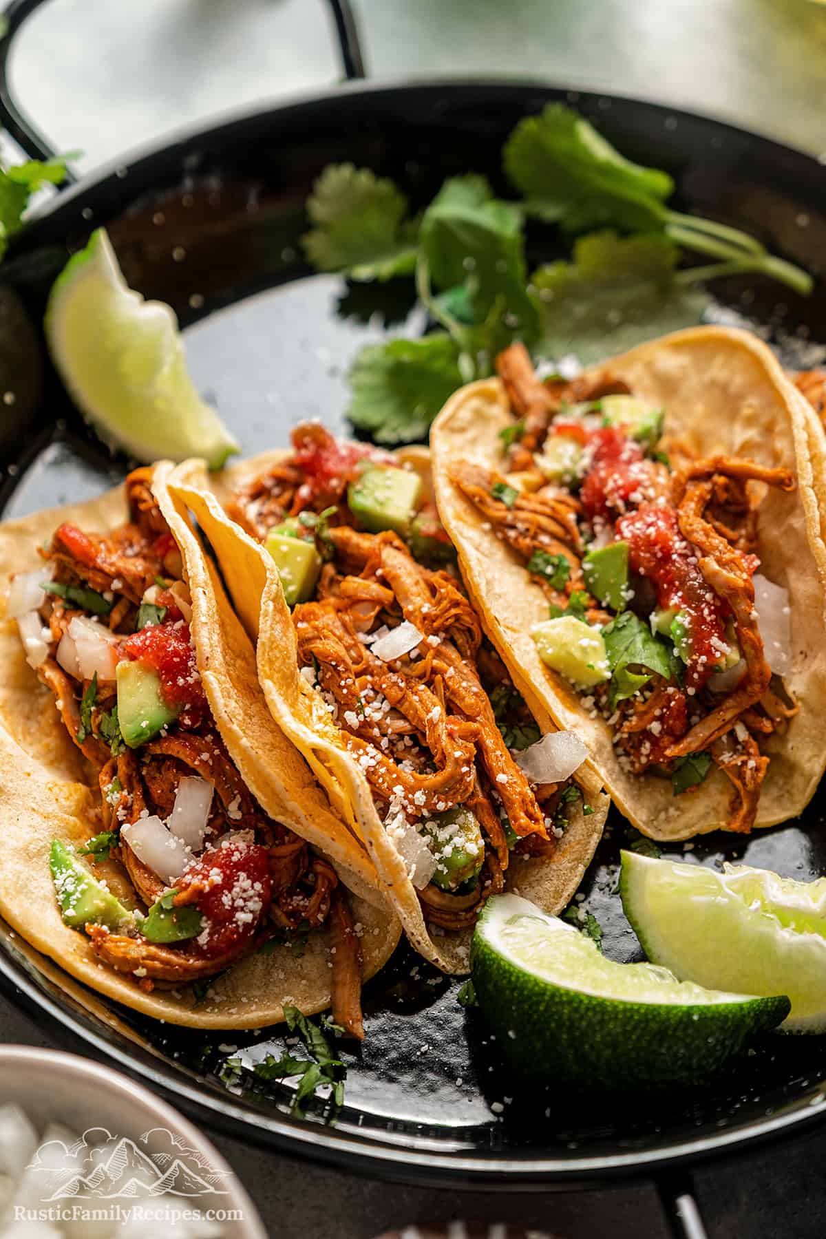 Three yucatan pork tacos with toppings.