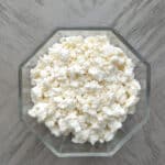 Overhead of cotija cheese in a glass bowl.