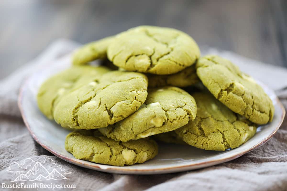 A pile of matcha white chocolate chip cookies on a white plate
