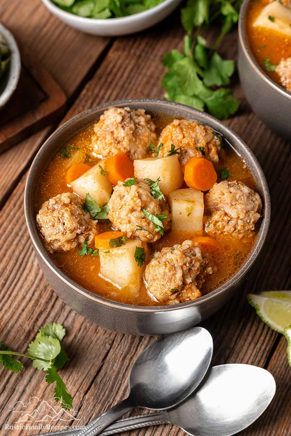A bowl filled with Albondigas Mexican Meatball Soup on a wood table