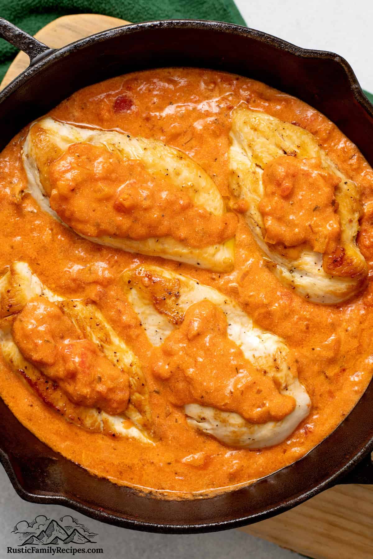 Chicken cooks in tomato sauce for a Chicken Sorrentino recipe.