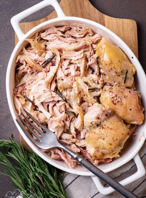 A white casserole dish filled with shredded roasted chicken