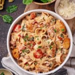 Tuscan chicken pasta served in a bowl with a fork and spoon