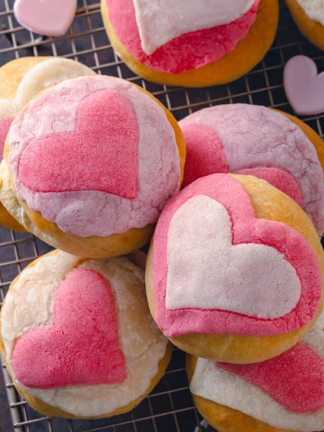 A stack of pink conchas with hearts