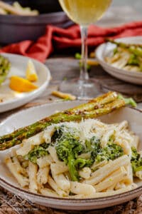 A plate of pasta served with roasted asparagus