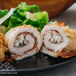 Cut open chicken rollatini on a plate with salad