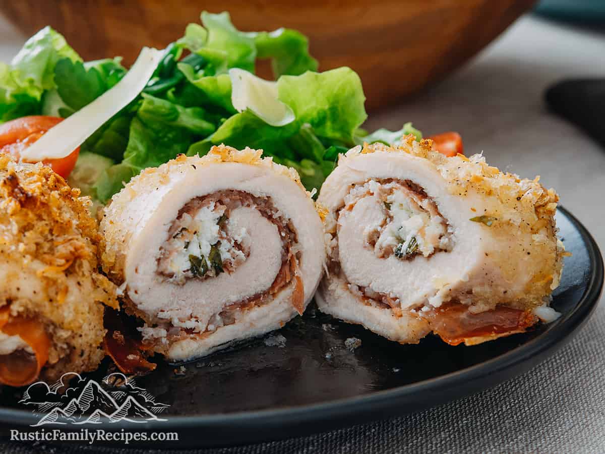 Cut open chicken rollatini on a plate with salad