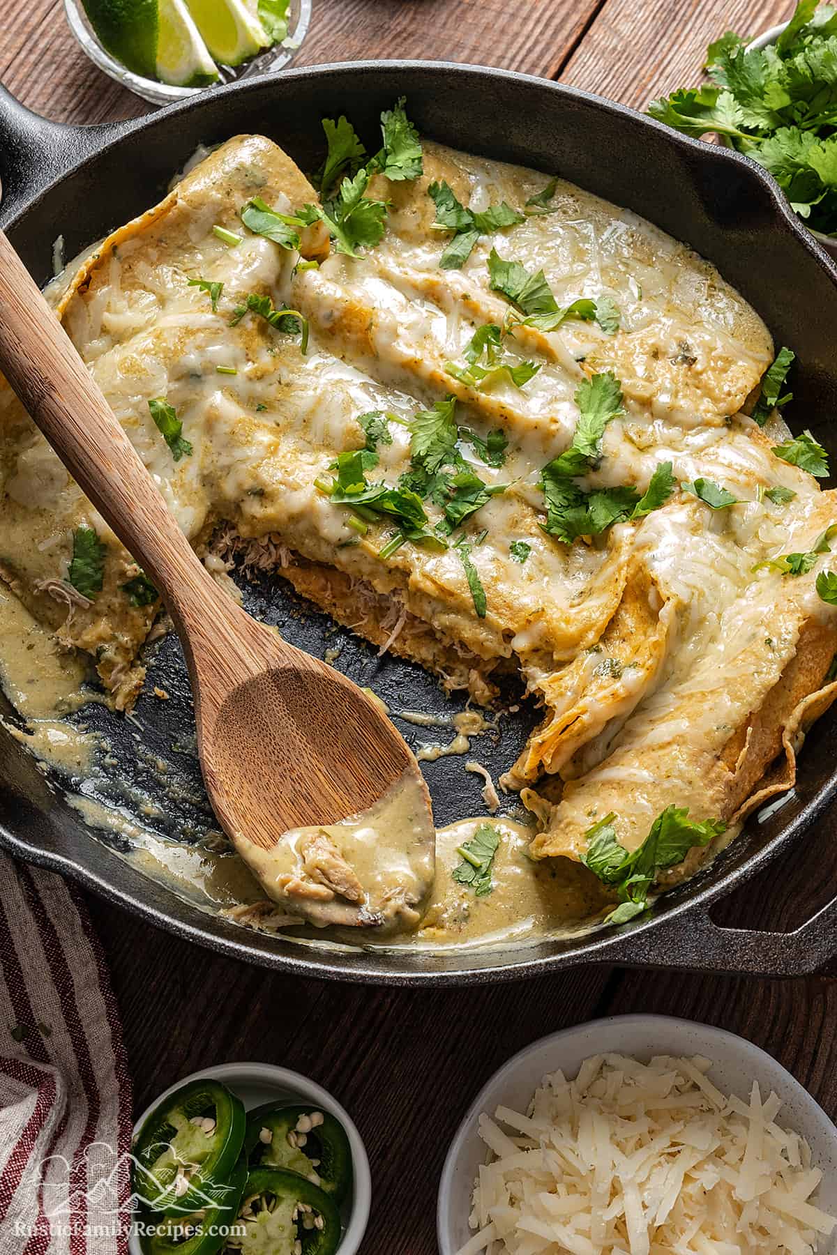Skillet with two missing enchiladas suizas. 