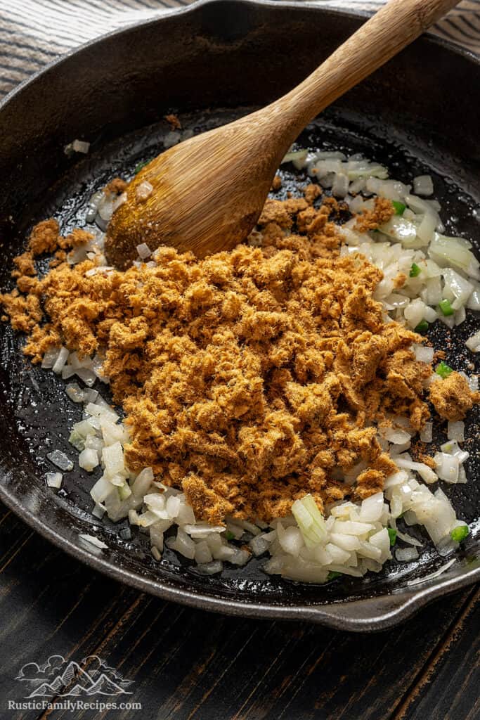 Adding the machaca to the onion and jalapeño mixture. 