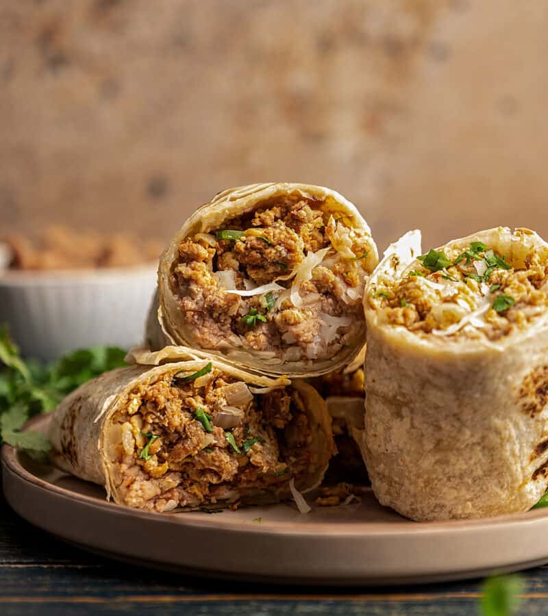 Halves of a machaca burrito on a plate.