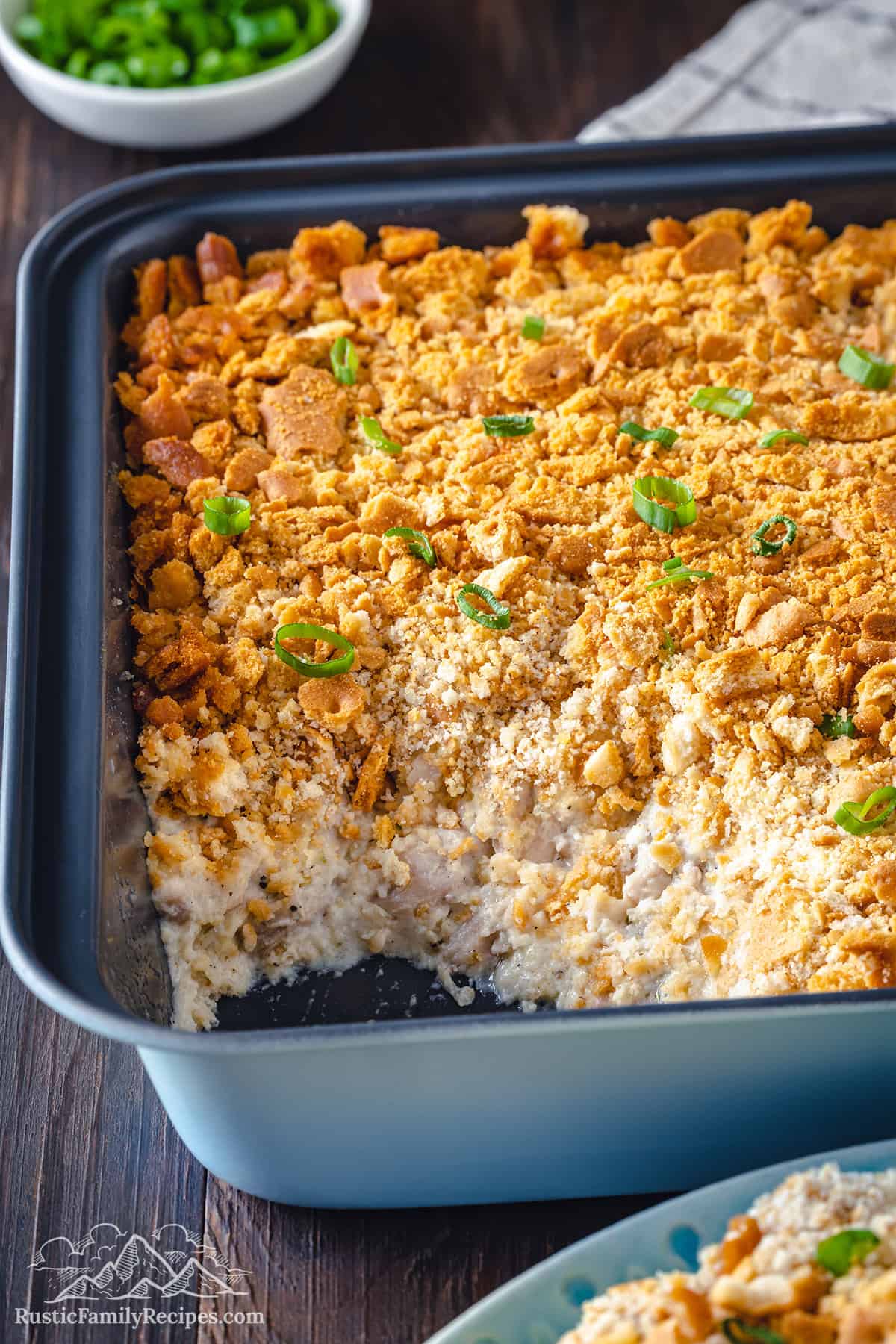 Million dollar chicken casserole in a blue baking dish with a slice taken out