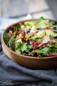 A wood bowl filled with spring mix salad