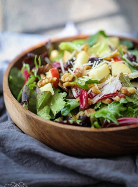 A wood bowl filled with spring mix salad