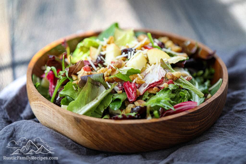 A wood bowl filled with spring mix salad