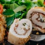 Cut open chicken rollatini on a plate with salad