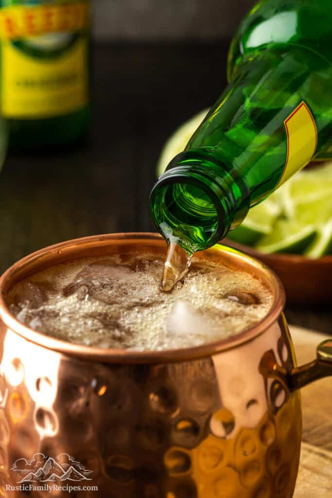 Pouring ginger beer into a copper mug