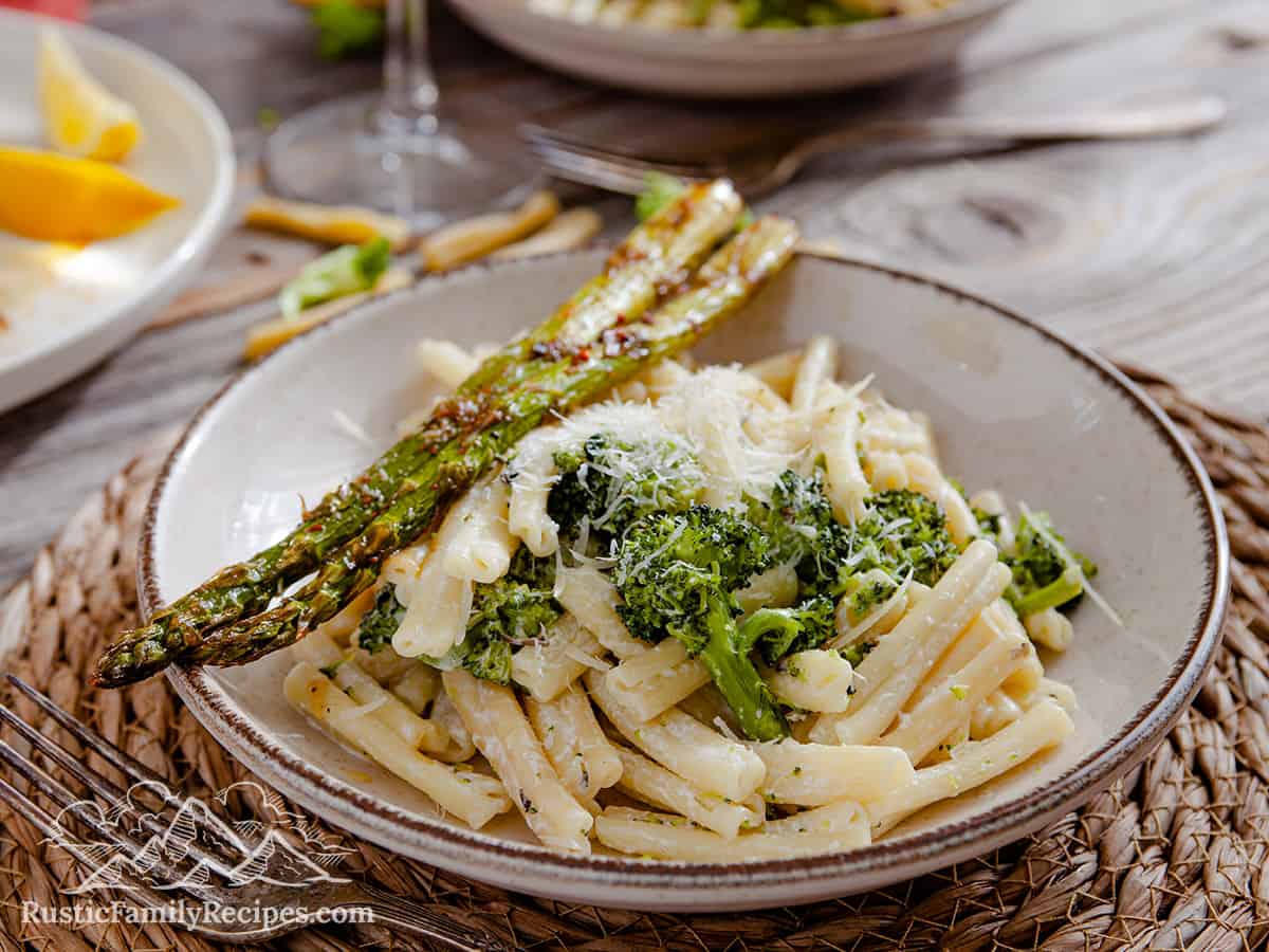 A plate of pasta served with roasted asparagus