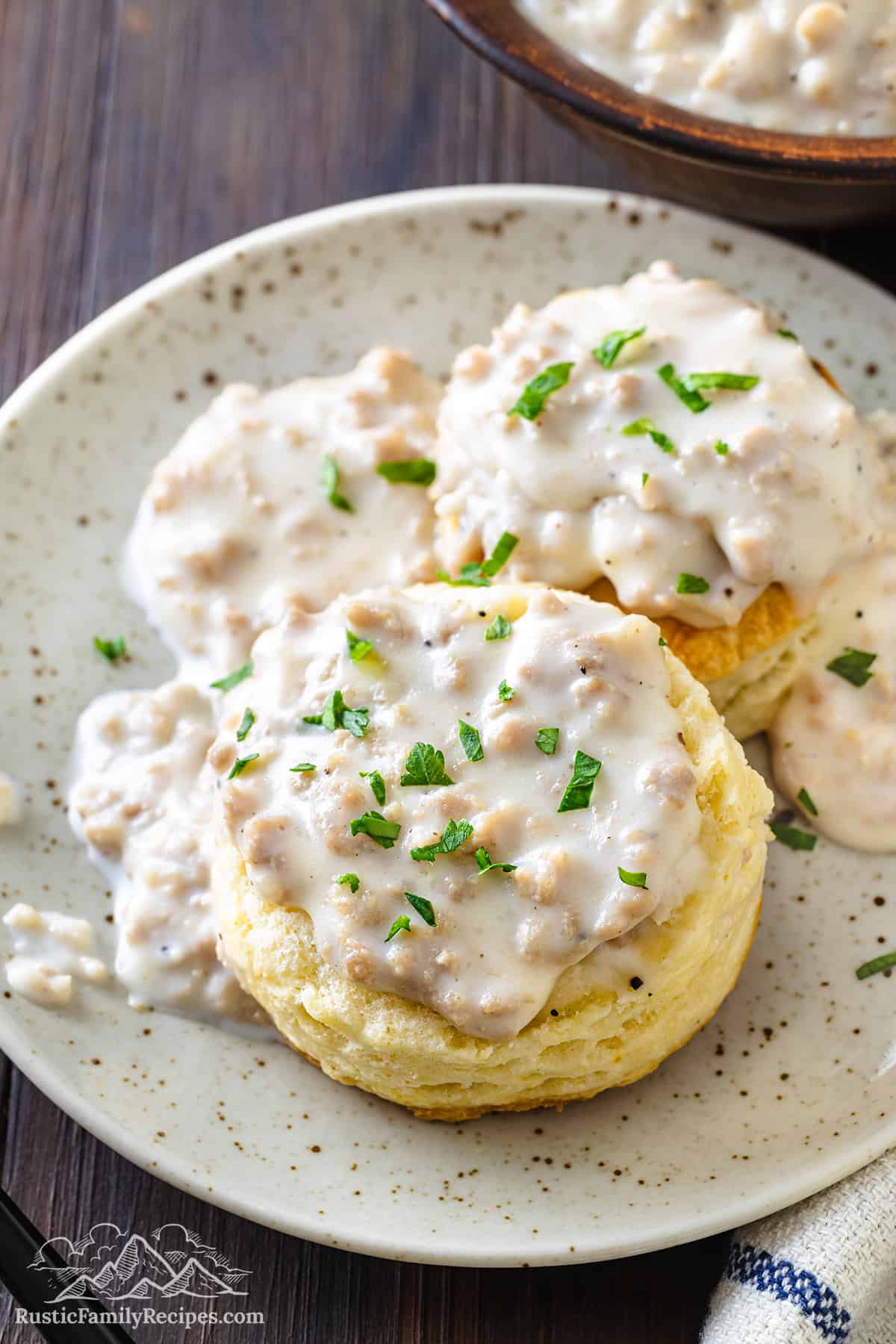 Closeup of cathead biscuits and gravy on a plate.