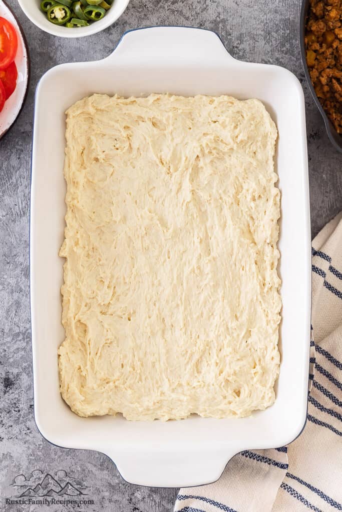 Layering biscuit dough in a baking dish