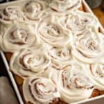 A baking dish filled with homemade frosted cinnamon rolls.