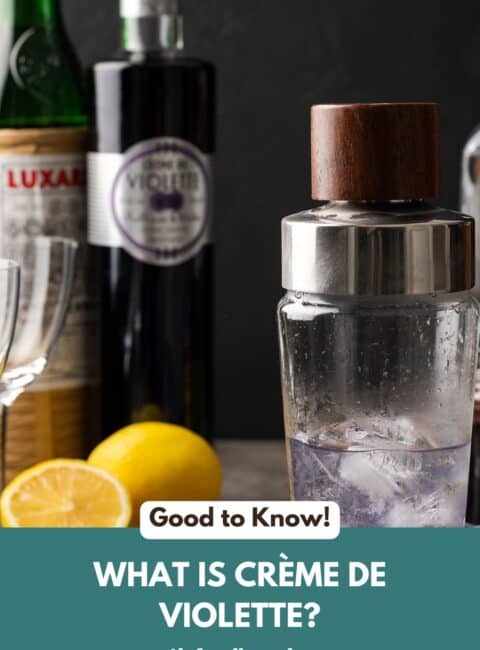 A bottle of creme de violette along with a lemon and cocktail shaker