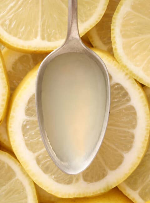 Top view of metallic spoon with lemon juice on it